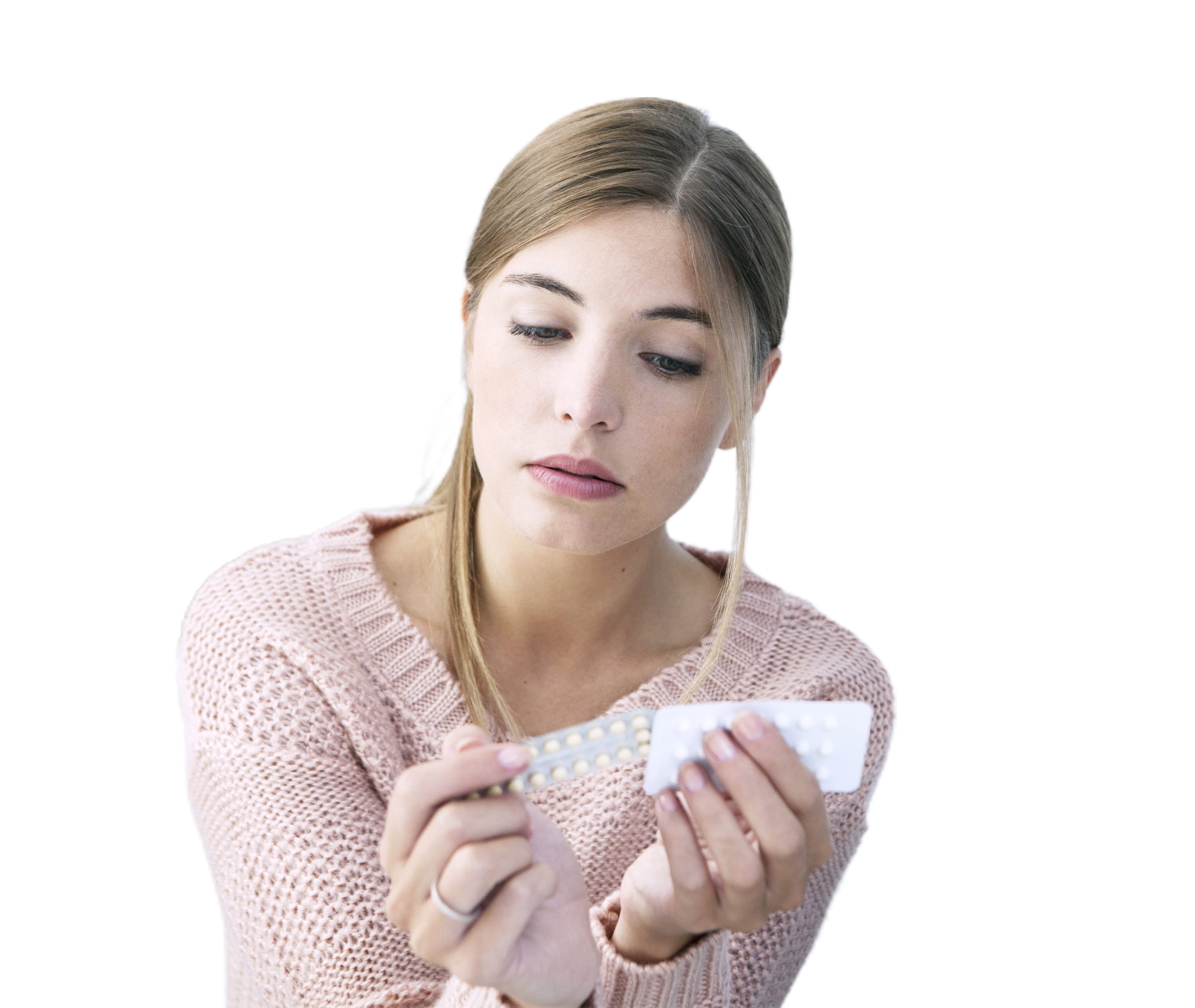 Blonde woman looking at blister packs of contraceptive pills